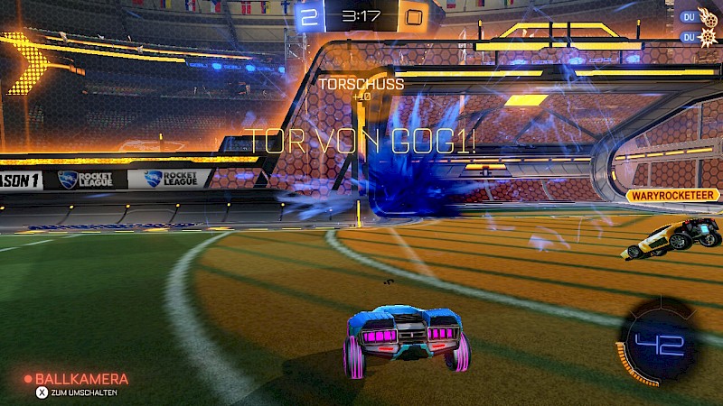 Ein Screenshot von Rocket League. Team Blau erzielt ein Tor. Der Ball explodiert im gegnerischen Tor in blauer Farbe.