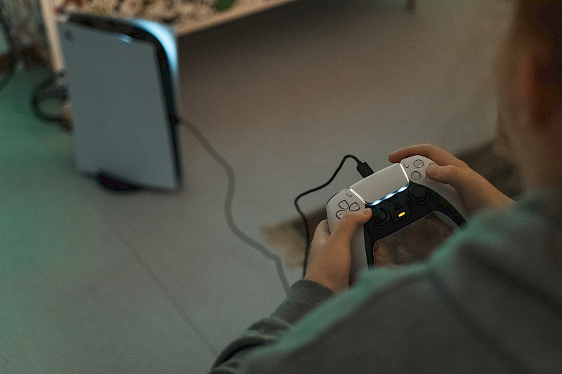 Ein Spieletester hält einen PlayStation 5 Controller in der Hand