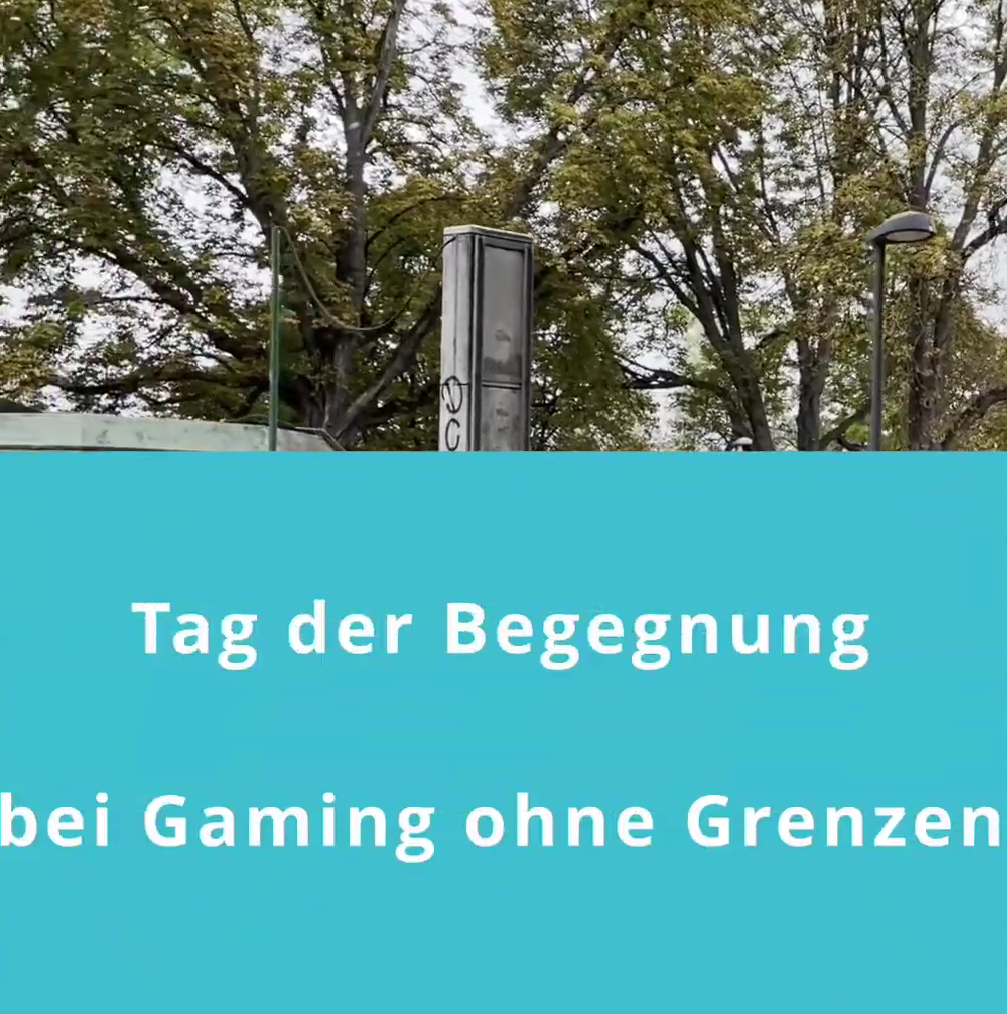 Schriftzug Tag der Begegnung bei Gaming ohne Grenzen auf einem hellblauen Hintergrund. Oberhalb sind Bäume im Hintergrund.