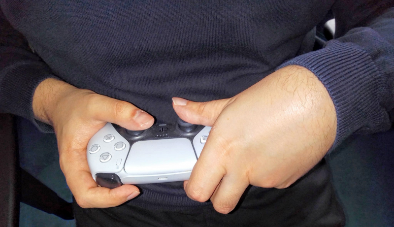 Die Hände von Lukas halten einen PS5 Controller.