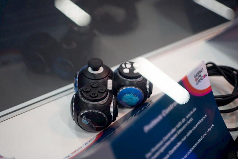 Ein Proteus Controller in einer Vitrine. Er besteht aus drei Modulen, mit Knöpfen und einem Joystick darauf.